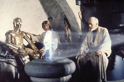 C-3PO, Luke Skywalker und Obi-Wan Kenobi betrachten ein Hologramm von Prinzessin Leia